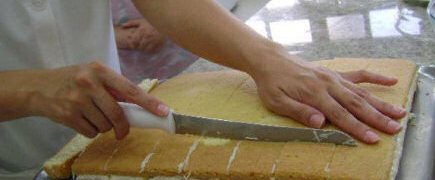 cortando bolo de coco recheado